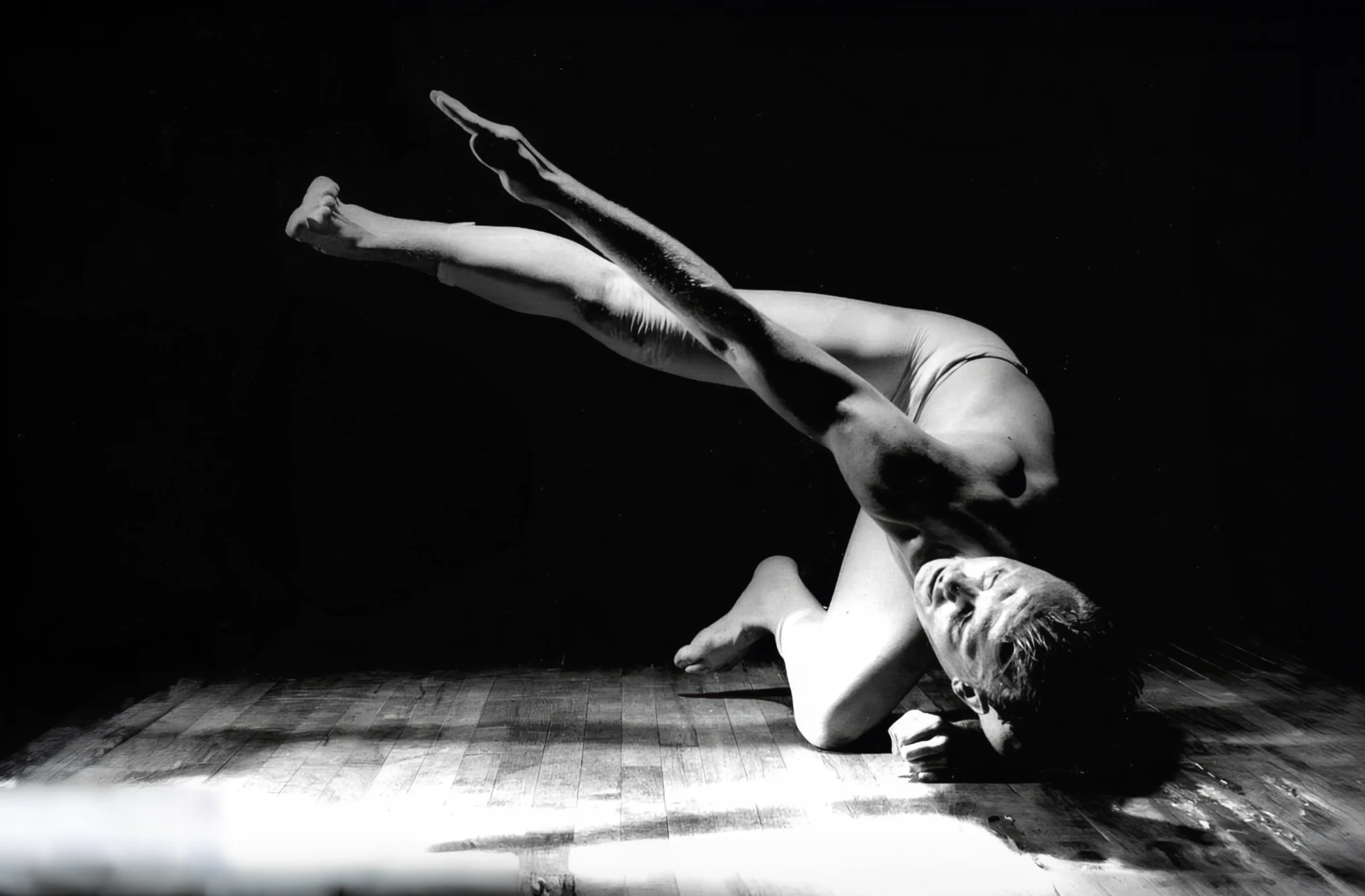 Mitchum Todd in a grounded floor pose, legs extended diagonally